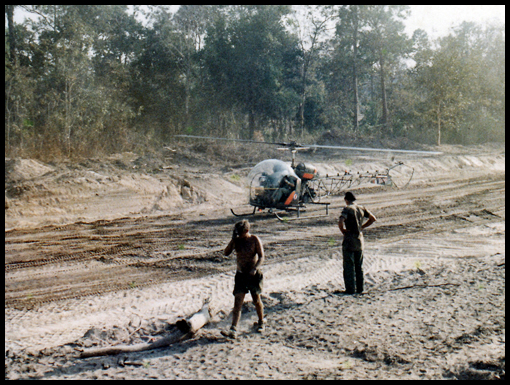 A Scout helicopter parks on the road formation.