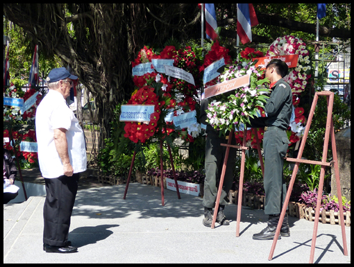 Bill Edwards waits patiently as his escorts adjust the wreath he is laying.