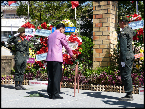 The Governor of Ubon bows to the wreath he's just placed on the stand.