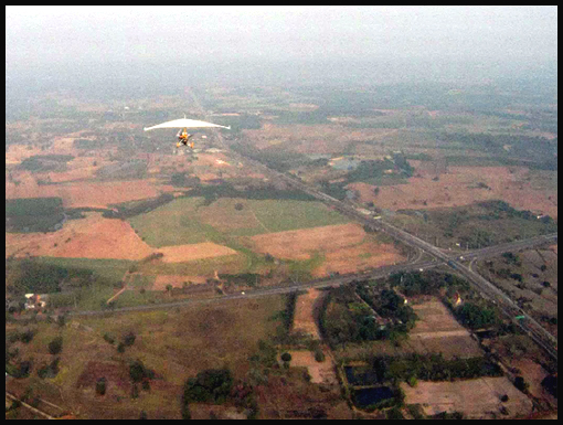 An in-flight view of U-P98 passing over x-roads to the south of Sa Kaeo.