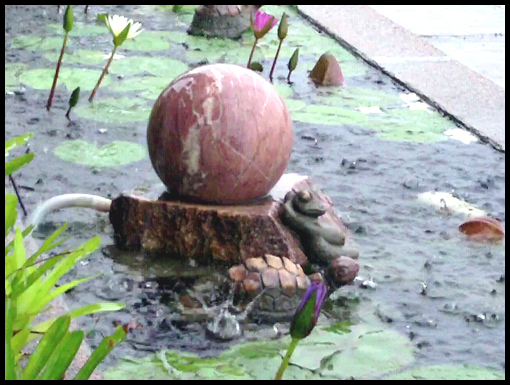 Raindrops fall into the water feature outside the Pudin Hotel in Loeng Nok Tha