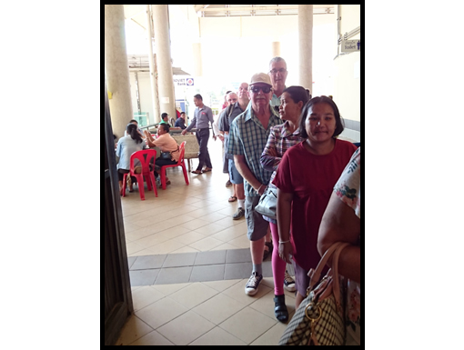 The travellers wait in line to depart from Laos