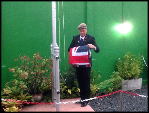 Julian Strathearn lowers and hands over the Union Jack to Mike Chapman.