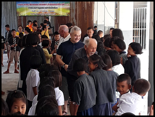 Jim Curtis and Noel Jackson move along the corridor of happy children.