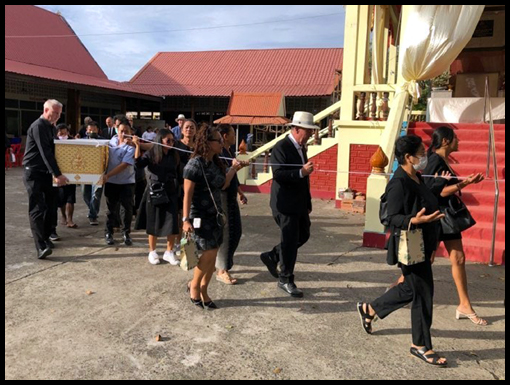 The coffin containing Mike Chapman's remains is escorted by mourners to the crematorium for cremation.