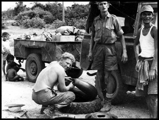 Sapper Dave Mears repairs a puncture at the side of the road.