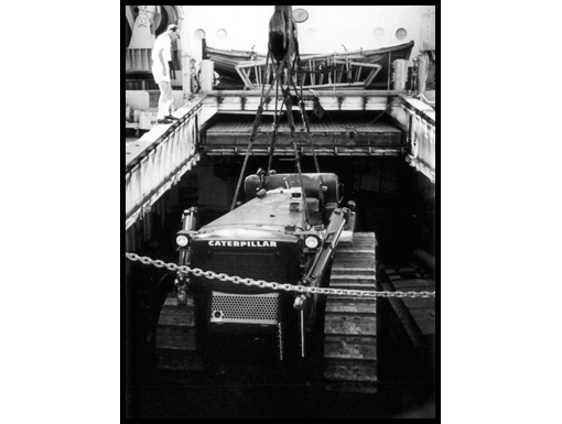 A Caterpillar D8 Bulldozer destined for Operation Crown is lifted from the hold of a ship in Bangkok harbour.