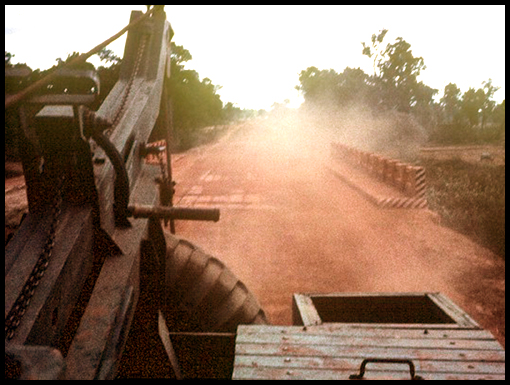 Clouds of red dust and rickety bridges circa 1960's Thailand