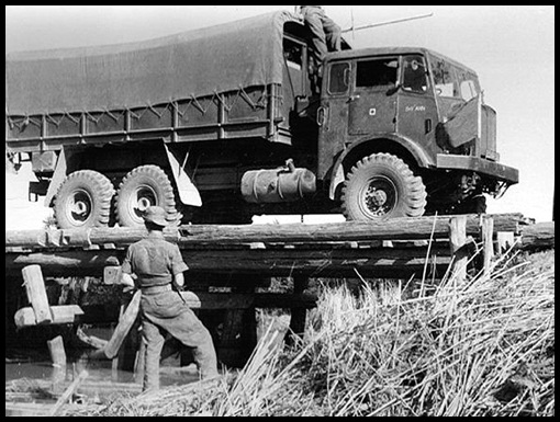 A Matador truck gingerly negotiates a wooden trestle bridge.