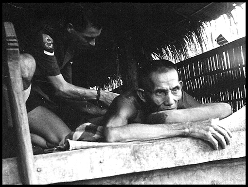 John Knowles administers an injection to an old man with TB.